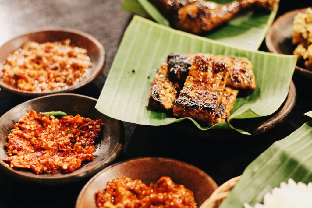 three plates of chili sambal and a plate of tempeh